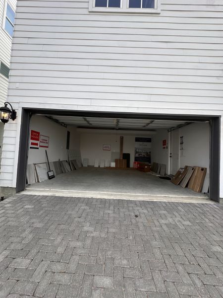 A spacious modern garage with white siding in Timbergrove Green by InTown Homes (Houston, TX).