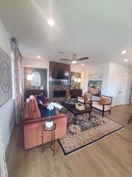 A cozy living room featuring a rustic brick fireplace, elegant rug, and plush seating. A cozy living room featuring a rustic brick fireplace, elegant rug, and plush seating.
