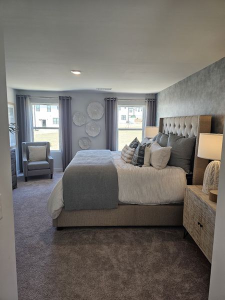 A cozy bedroom with a tufted headboard, soft gray bedding, and contemporary decor, creating a serene retreat. A cozy bedroom with a tufted headboard, soft gray bedding, and contemporary decor, creating a serene retreat.