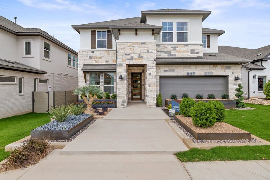 Front exterior of a home in the Park Collection At Wolf Ranch community, located in Georgetown, TX (Image 2).