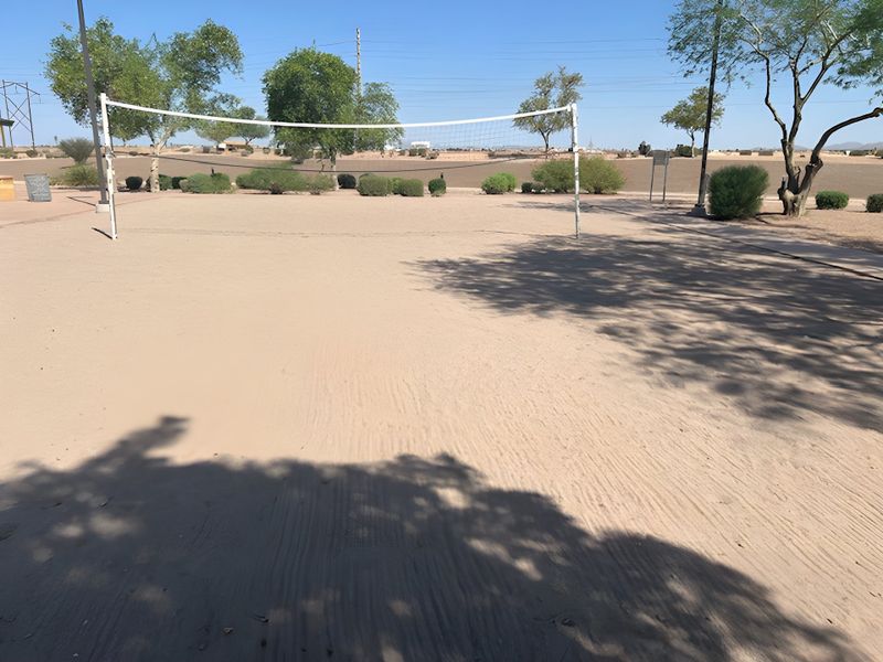 A sandy volleyball court nestled among trees in Magnolia at Desert Passage by KB Home (Maricopa, AZ).