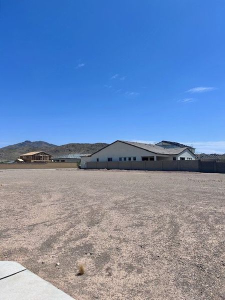 Expansive desert lot with a modern home at Laveen Vistas II by Homes by Towne, set against scenic Phoenix, AZ mountains. Expansive desert lot with a modern home at Laveen Vistas II by Homes by Towne, set against scenic Phoenix, AZ mountains.