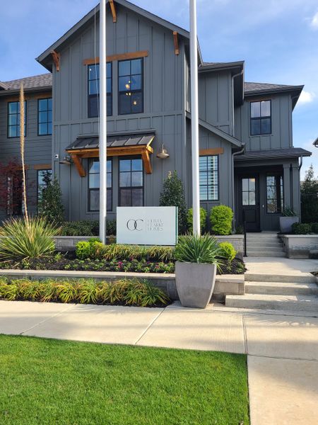 A charming gray home with lush landscaping in Fields by Olivia Clarke Homes (Frisco, TX).
