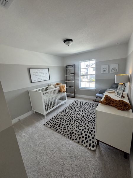 A cozy and modern nursery with a white crib, a comfortable armchair, and a stylish leopard-print rug. A cozy and modern nursery with a white crib, a comfortable armchair, and a stylish leopard-print rug.