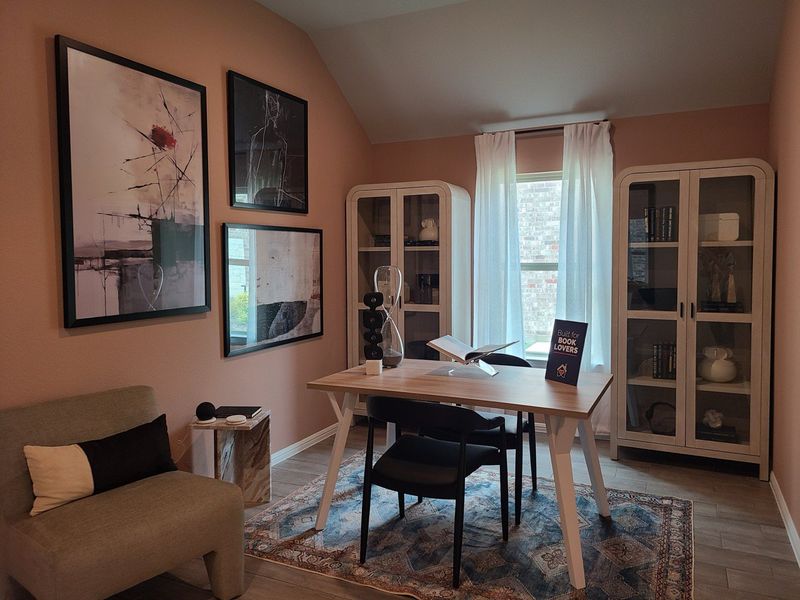 A cozy home office with modern art, bookshelves, a wooden desk, and natural light illuminating the space. A cozy home office with modern art, bookshelves, a wooden desk, and natural light illuminating the space.