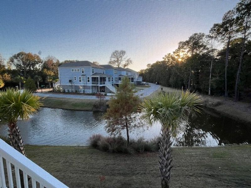 Beautiful lakeside homes in Liberty Hill Farm by K. Hovnanian® Homes, surrounded by lush trees in Mount Pleasant, SC.