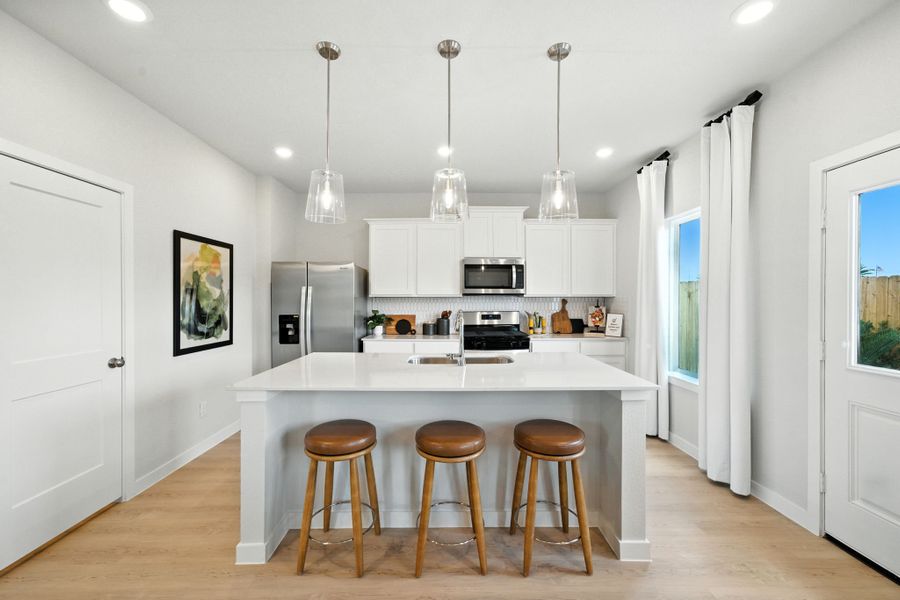 A kitchen with a bar stool and a table. A kitchen with a bar stool and a table.