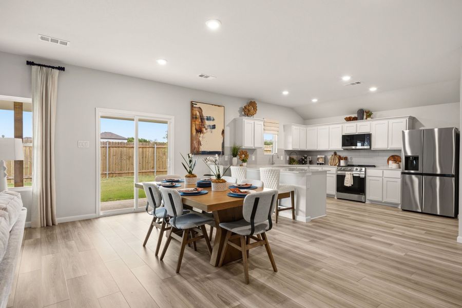 A kitchen with a dining table and chairs. A kitchen with a dining table and chairs.
