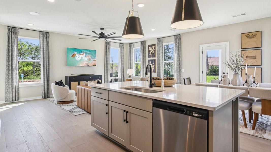 Open Concept first floor layout with cozy living room, kitchen island, and dining area near the back door