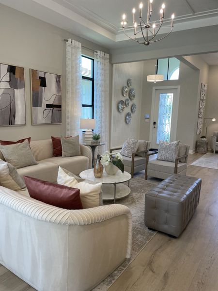 A chic living room with modern art, elegant seating, subtle lighting, and stylish decor accents.