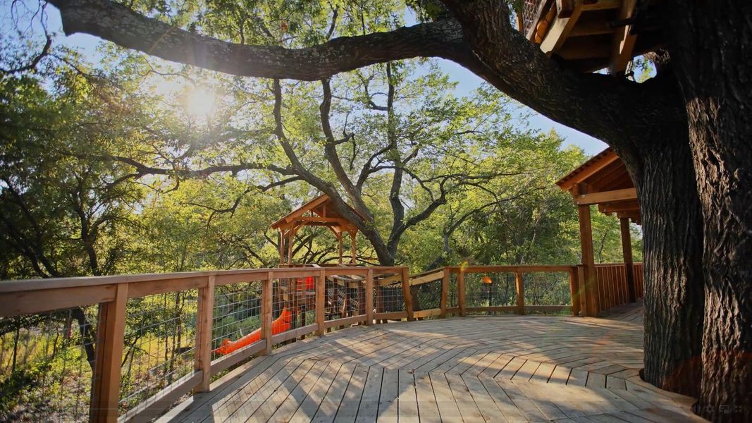Exquisite oak-surrounded wooden deck and treehouse in Solterra, Texas, offering serene views and unique charm.