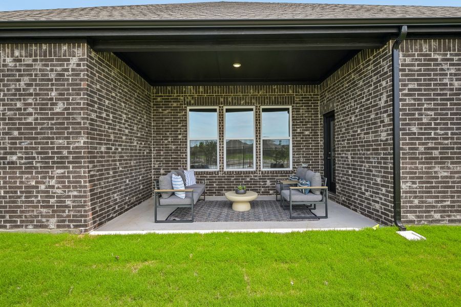 A brick building with a bench and a potted plant in the front.