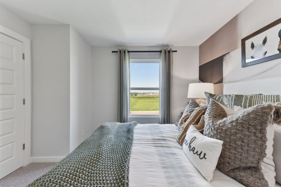 A bedroom with a large window. A bedroom with a large window.