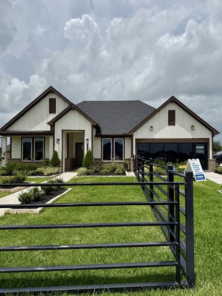A charming modern home with a manicured lawn in Tamarron by D.R. Horton (Fulshear, TX).