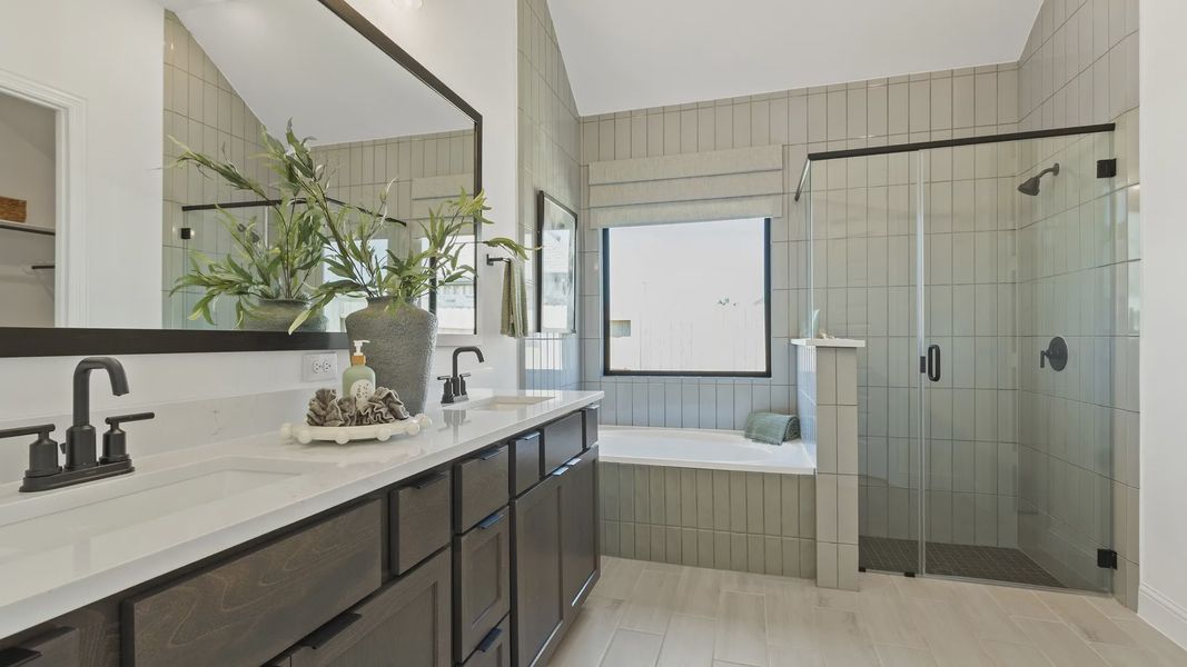 Revel in luxury with dual sinks, dark wood cabinets, glass shower, and soaking tub in Oakwood Estates. Revel in luxury with dual sinks, dark wood cabinets, glass shower, and soaking tub in Oakwood Estates.