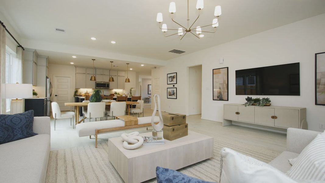 Luxurious open-plan living with chic chandelier and sleek design in The Woodlands Hills.