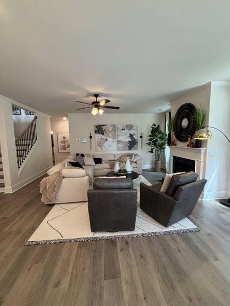A cozy living room with modern decor, featuring plush seating, elegant artwork, and warm wood floors.