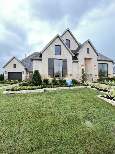 Elegant white brick home with tall windows and manicured lawn in Somerset Park 80' by Perry Homes (Rockwall, TX).
