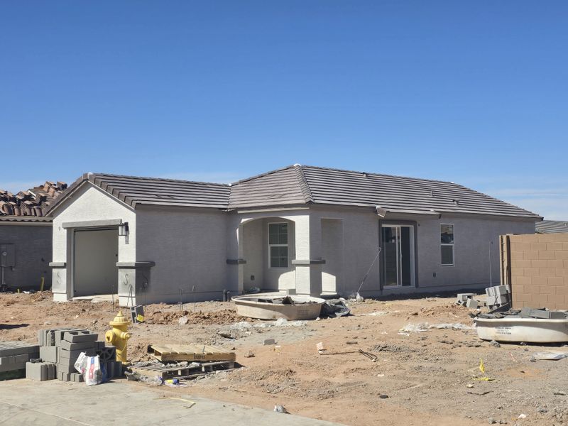 A modern, single-story home with a tile roof and garage in Anderson Farms: Premier by Lennar (Maricopa, AZ).