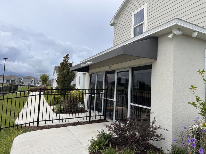 A charming modern building with landscaped paths and greenery in Waterstone by Taylor Morrison (Mascotte, FL).