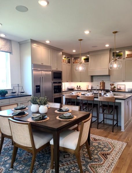 A contemporary kitchen with sleek cabinetry, an elegant island, and a cozy dining area on a stylish patterned rug.