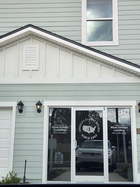 A charming light blue facade with modern glass doors at West Ortega Landing by D.R. Horton in Jacksonville, FL.