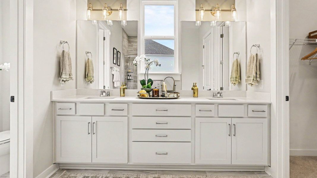 Primary bathroom with dual vanity and bright natural lighting Primary bathroom with dual vanity and bright natural lighting