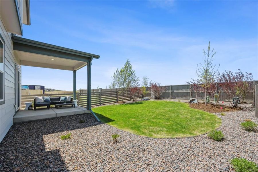 A backyard with a covered patio.