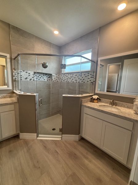 Large bathroom with a spacious glass-enclosed shower, dual vanity, and neutral tones.