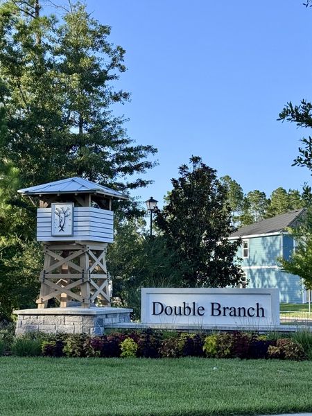 A beautifully landscaped entrance at Double Branch by Pulte Homes in Middleburg, FL, featuring elegant signage and lush greenery.