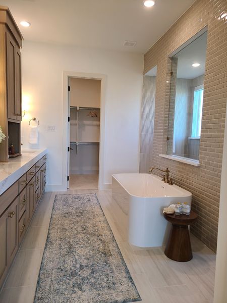 A luxurious bathroom featuring a freestanding tub, wood cabinetry, and elegant tile accents. A luxurious bathroom featuring a freestanding tub, wood cabinetry, and elegant tile accents.