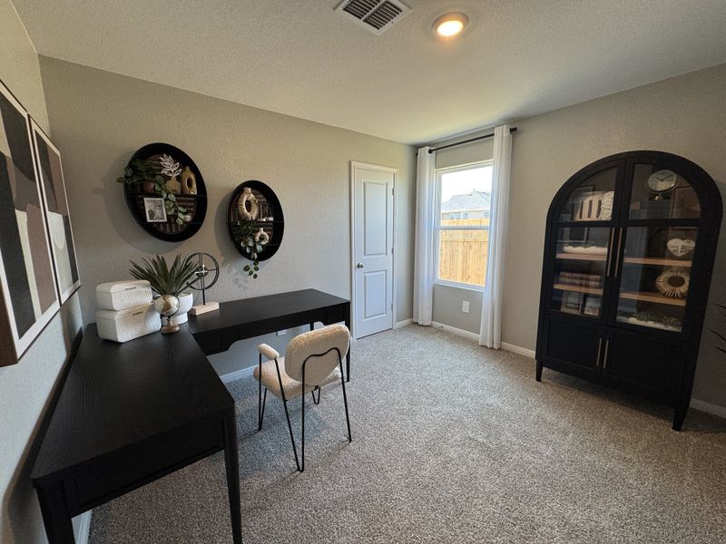 A cozy office space with a sleek black desk, modern shelving, and elegant decor, set on soft carpeted flooring. A cozy office space with a sleek black desk, modern shelving, and elegant decor, set on soft carpeted flooring.
