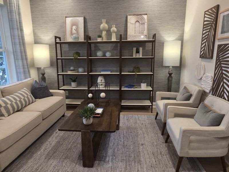 A cozy living room featuring neutral furniture, elegant shelving, stylish decor, and soft lighting accents. A cozy living room featuring neutral furniture, elegant shelving, stylish decor, and soft lighting accents.