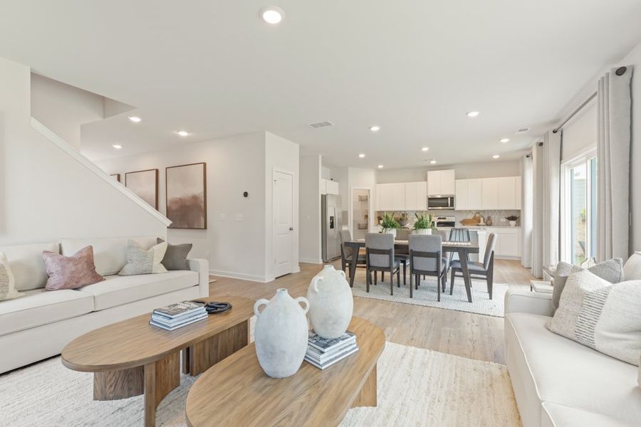 A living room with a table and chairs. A living room with a table and chairs.