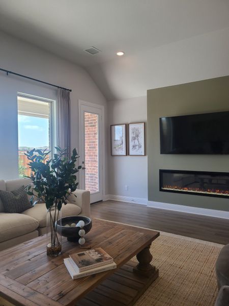 A cozy living space featuring a modern fireplace, plush seating, natural wood accents, and abundant natural light.