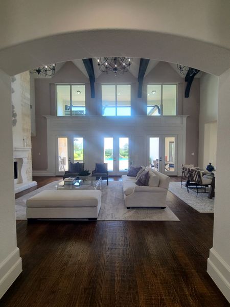 An elegant living area with high ceilings, exposed beams, plush seating, and abundant natural light. An elegant living area with high ceilings, exposed beams, plush seating, and abundant natural light.