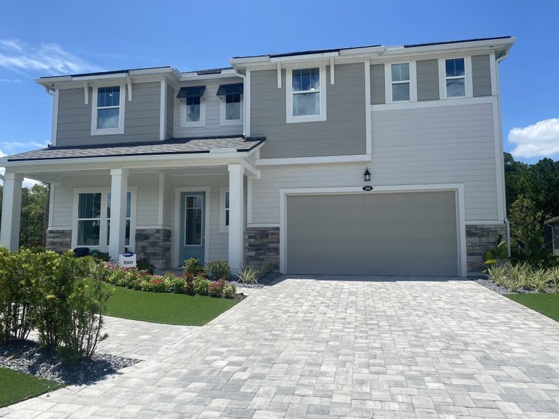 A beautiful two-story home featuring a paved driveway, porch, and landscaping in RiverTown - Vista by Mattamy Homes (St. Johns, FL). A beautiful two-story home featuring a paved driveway, porch, and landscaping in RiverTown - Vista by Mattamy Homes (St. Johns, FL).