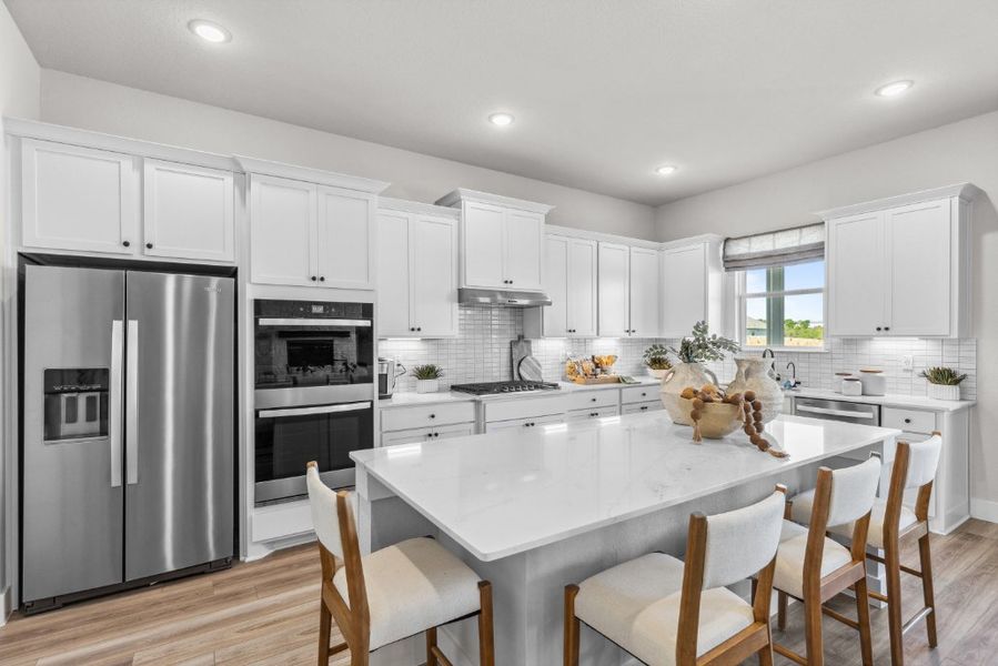 A kitchen with white cabinets.