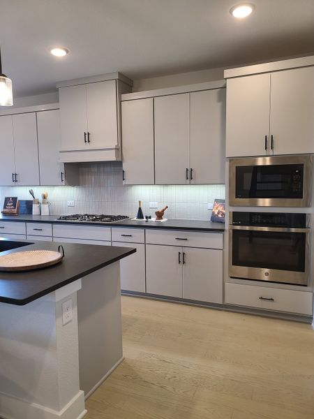 A modern kitchen with sleek cabinets, stainless steel appliances, and under-cabinet lighting.