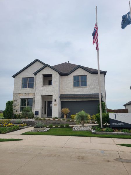 Elegant white brick home with manicured landscaping in Windmore by Trophy Signature Homes (Princeton, TX).