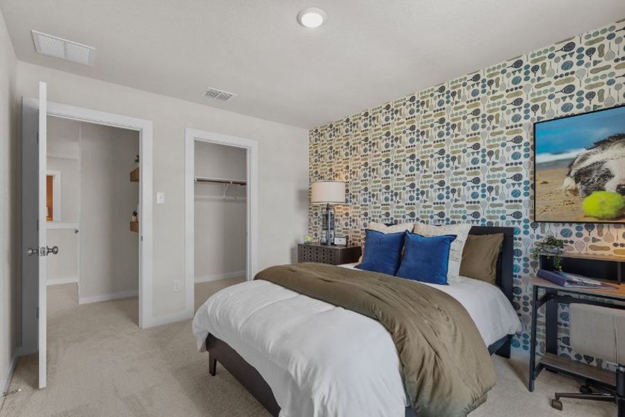 A bedroom with a bed and a lamp.