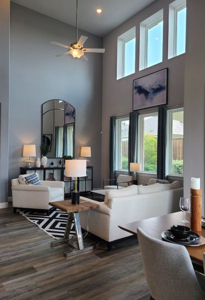 A sophisticated living room with high ceilings, modern decor, and large windows for natural light. A sophisticated living room with high ceilings, modern decor, and large windows for natural light.