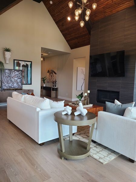 A modern living room featuring high ceilings, cozy sofas, and a chic chandelier for a warm, inviting atmosphere. A modern living room featuring high ceilings, cozy sofas, and a chic chandelier for a warm, inviting atmosphere.