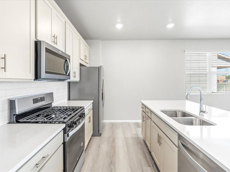 Kitchen in the Woodland floorplan at a Meritage Homes community in Broomfield, CO.