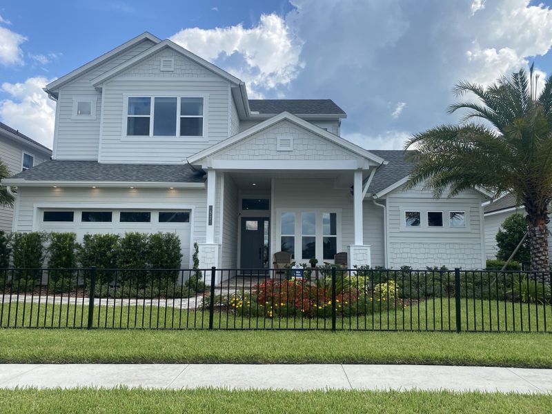 A beautiful white home with a charming front porch and lush landscaping in Reflections at Seabrook by ICI Homes (Nocatee, FL). A beautiful white home with a charming front porch and lush landscaping in Reflections at Seabrook by ICI Homes (Nocatee, FL).