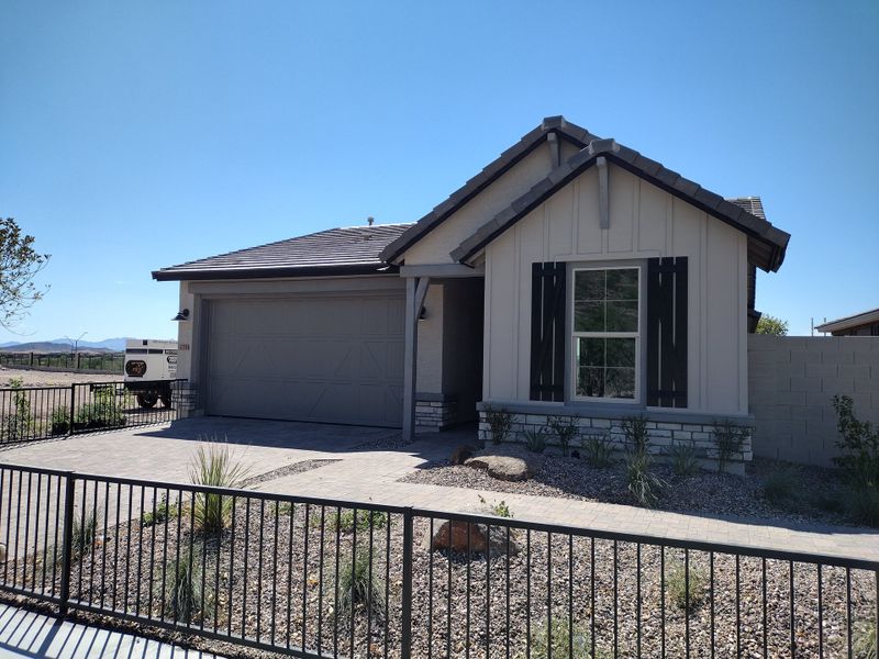 A charming single-story home with shutters and desert landscaping in The Villas at Mystic by Brightland Homes (Peoria, AZ).