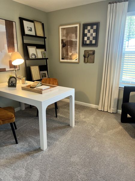A cozy home office with a sleek white desk, stylish artwork, and chic decor accents.