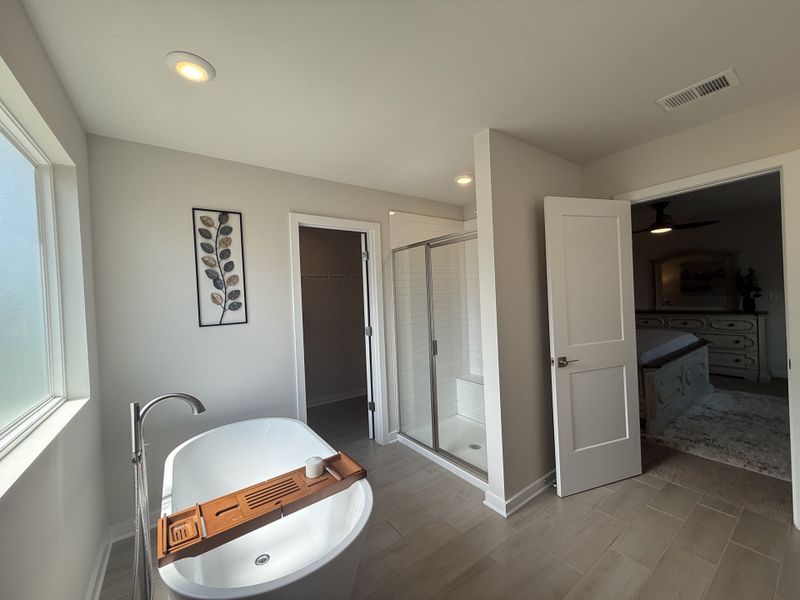 A bright bathroom featuring a sleek freestanding tub, glass shower, and elegant wall decor. A bright bathroom featuring a sleek freestanding tub, glass shower, and elegant wall decor.