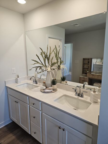 A modern bathroom with dual sinks, sleek faucets, and elegant decor in a spacious and bright setting. A modern bathroom with dual sinks, sleek faucets, and elegant decor in a spacious and bright setting.