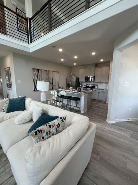 A modern living area with an open floor plan, comfy white sectional, and elegant kitchen with sleek cabinetry and stylish decor. A modern living area with an open floor plan, comfy white sectional, and elegant kitchen with sleek cabinetry and stylish decor.